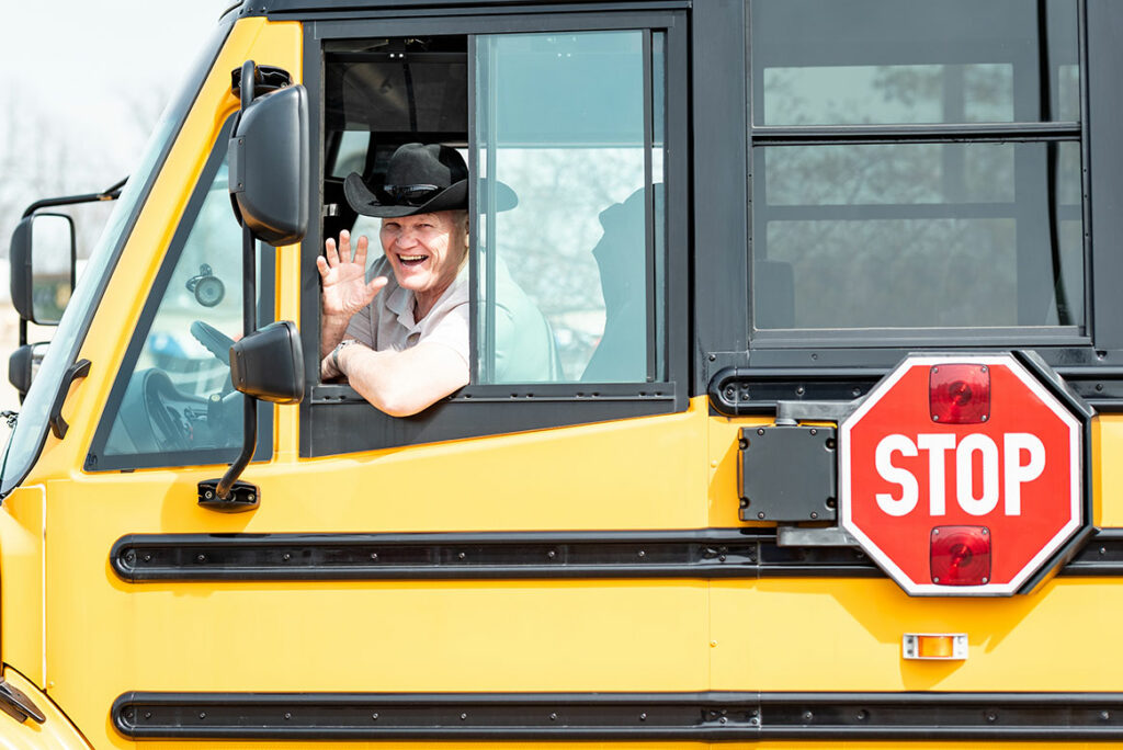 school bus driver smiling and waving out of the window